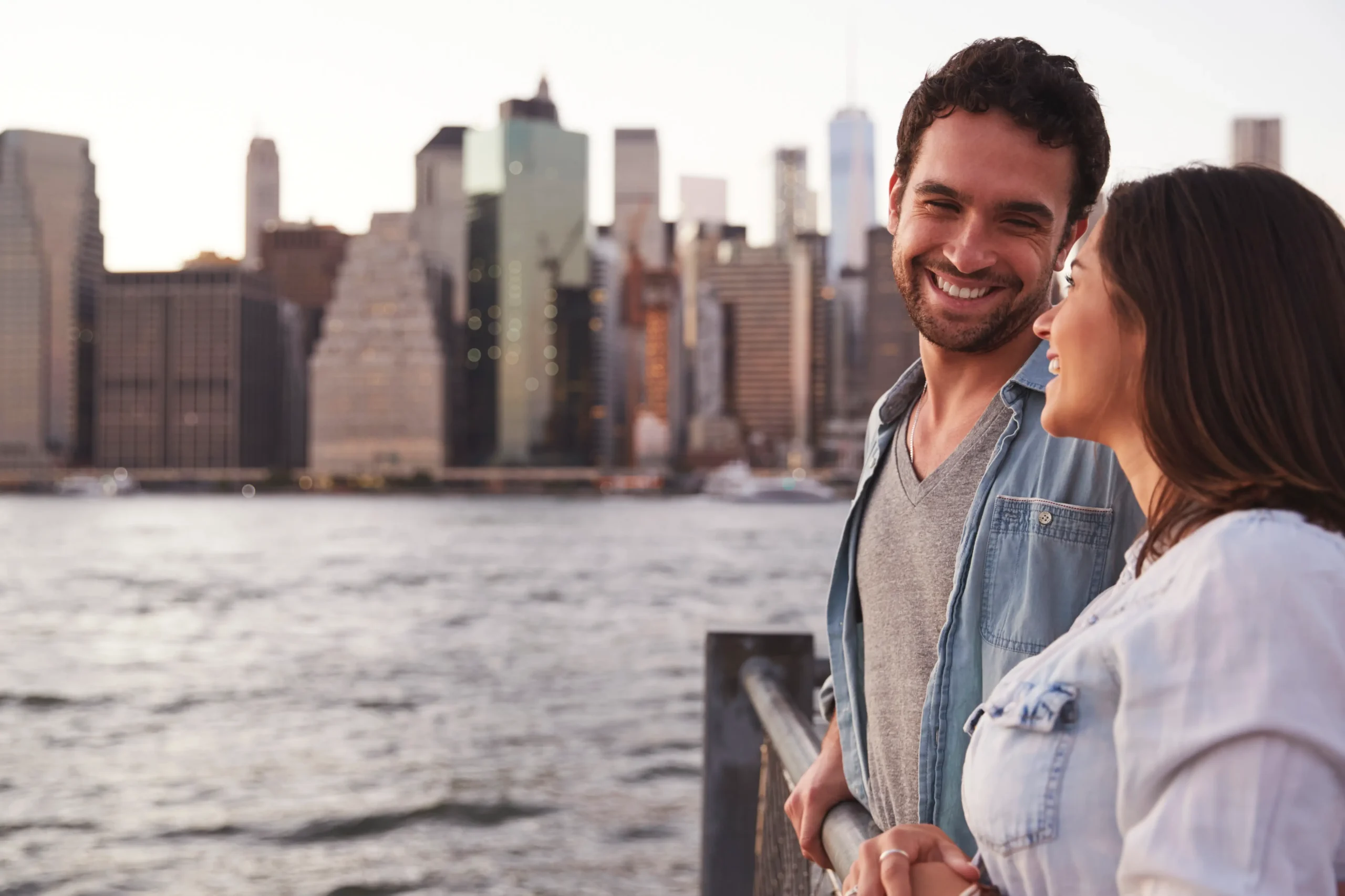 A man standing on a rooftop with the New York City skyline in the background